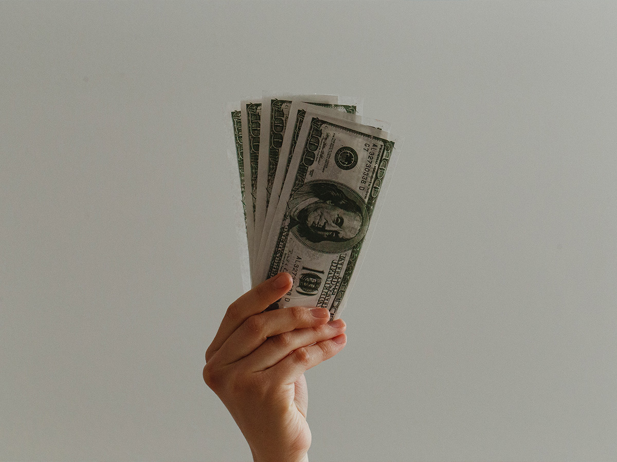 A hand holding up cash