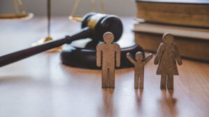 wooden figures of family in front of court gavel