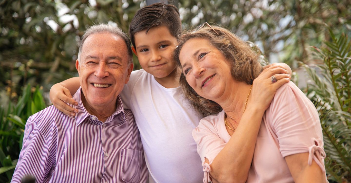 an older couple smiling and embracing a child
