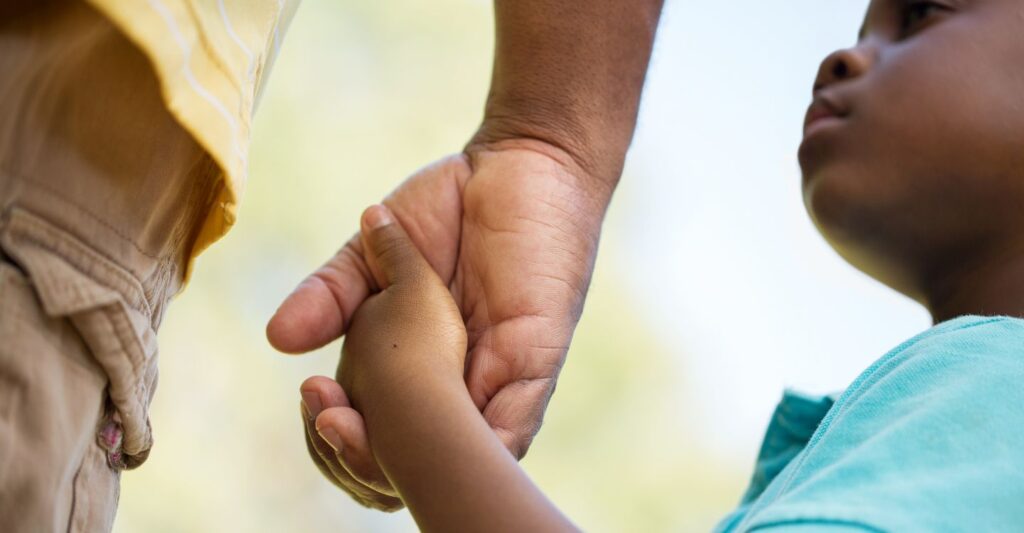 a parent and child holding hands