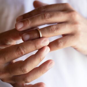 person removing wedding ring from finger