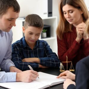 parents signing paperwork in front of child