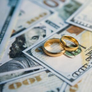 marriage rings on stacks of cash