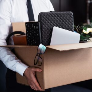 a business man carrying a box of office stuff