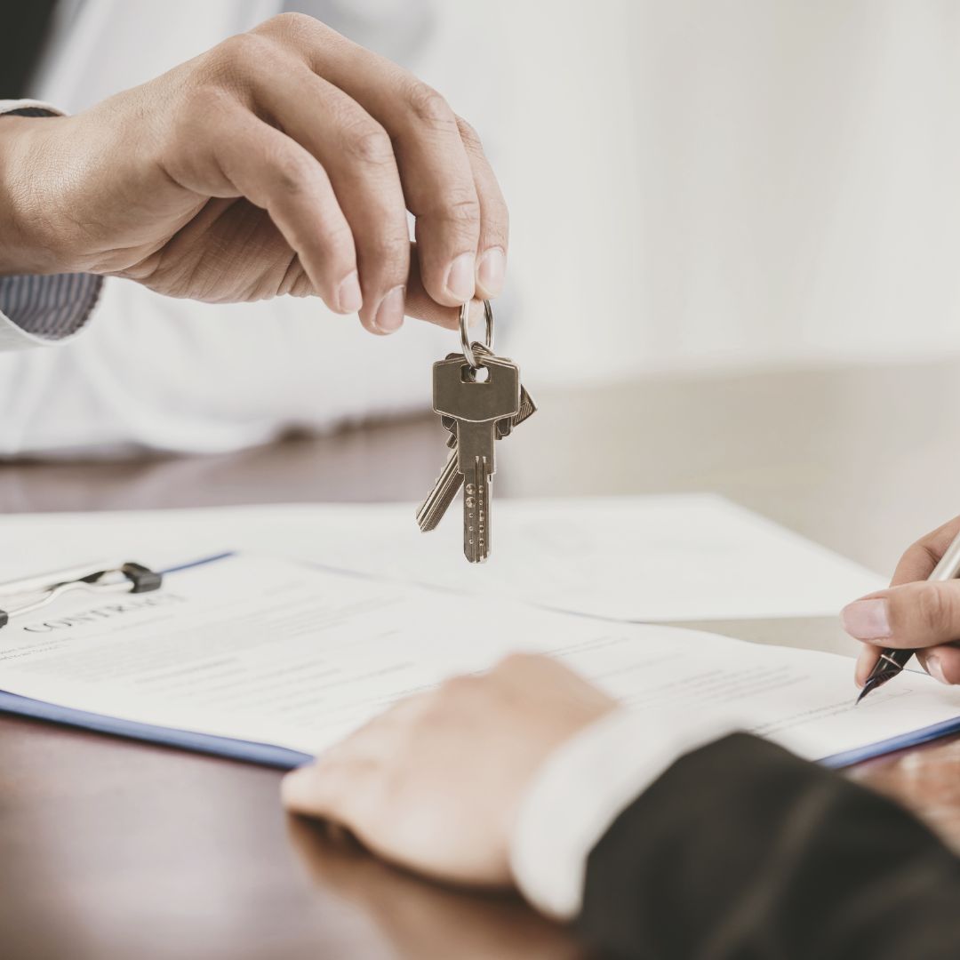 filling out a form and someone handing over a set of keys