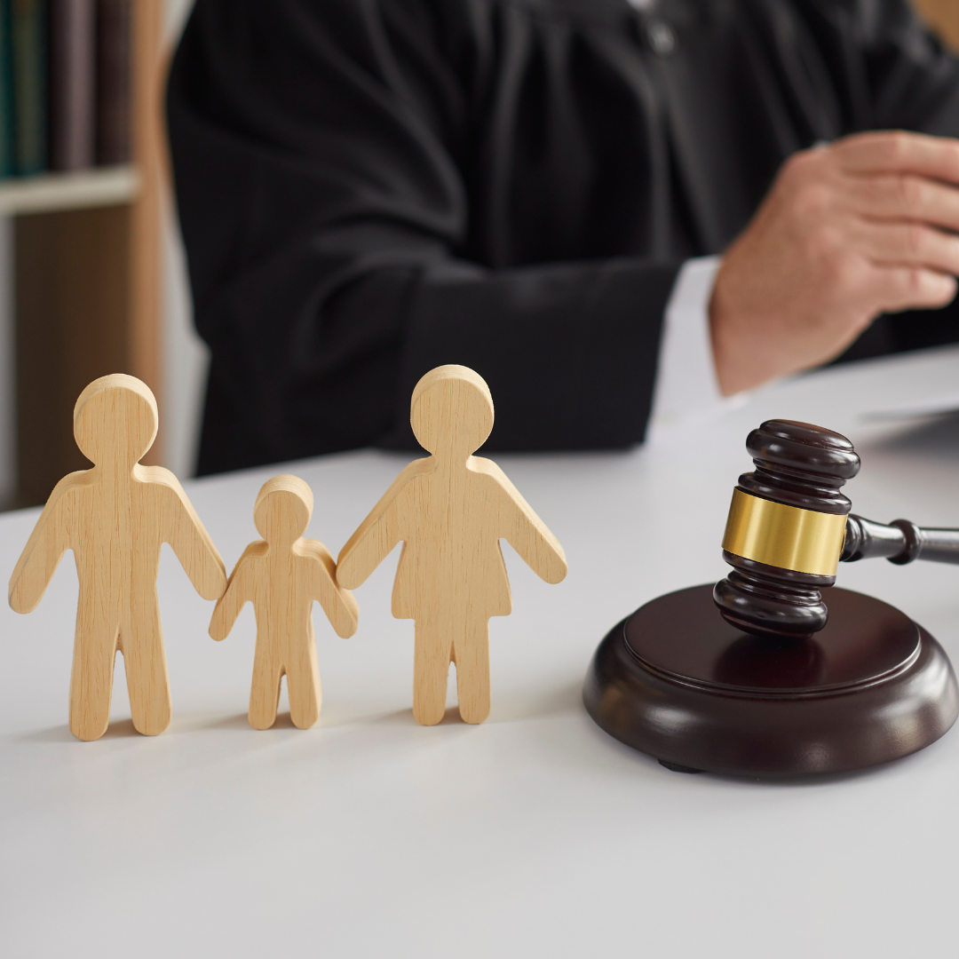 Wooden structure of a family next to a gavel. 