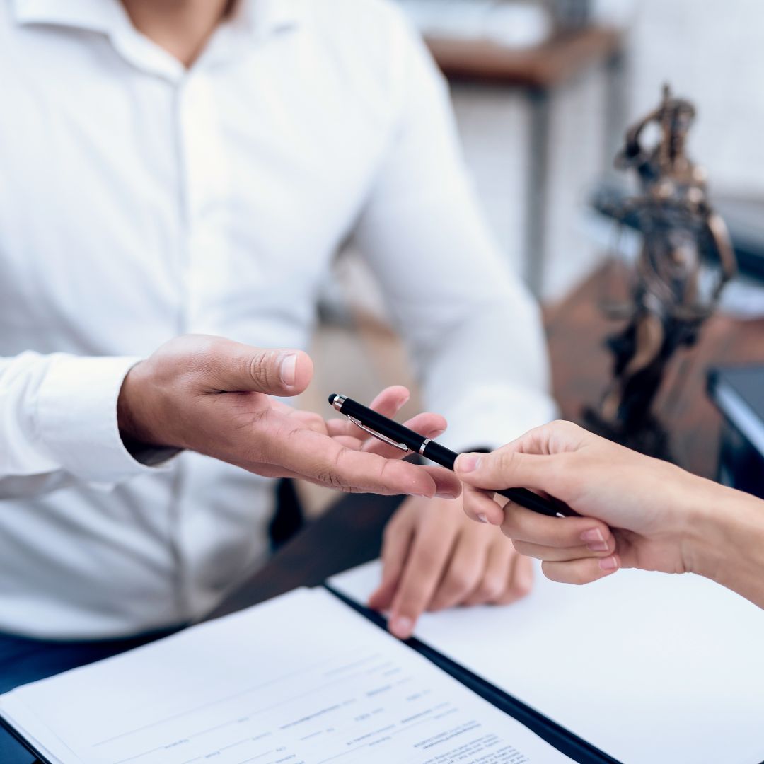 lawyer handing pen to client