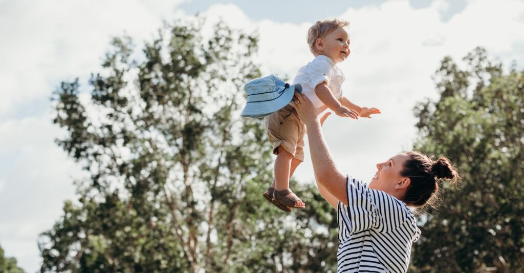 woman tosses kid up in the air playfully