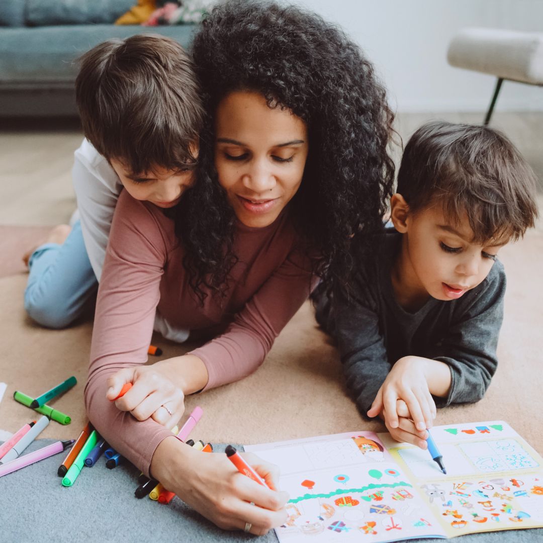woman lays on floor with children