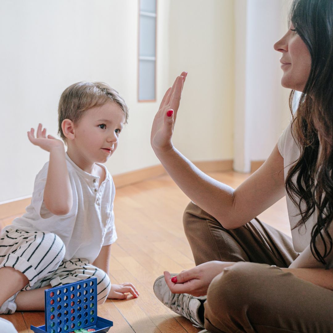 woman holds her hand up for kid to high five