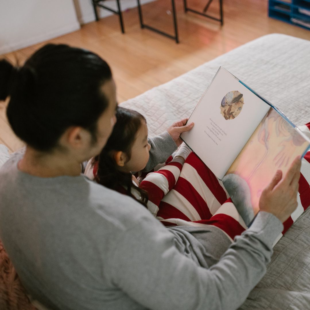 man reads to child sitting on lap
