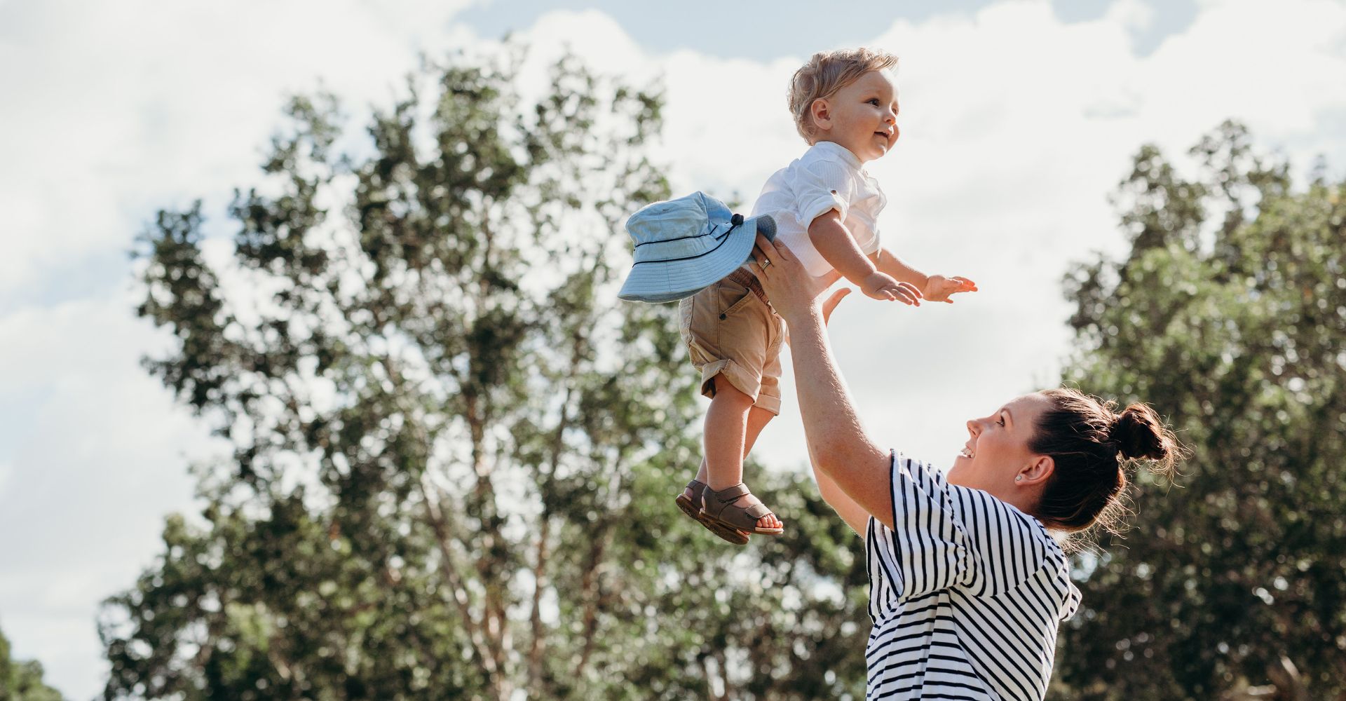 woman tosses kid up in the air playfully