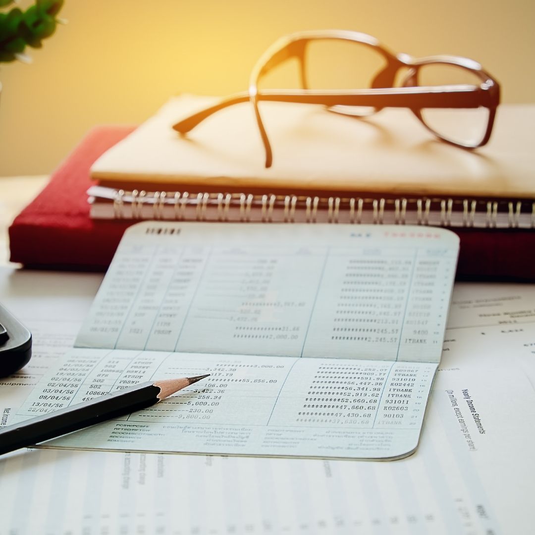 checkbook payments log with pencil and glasses