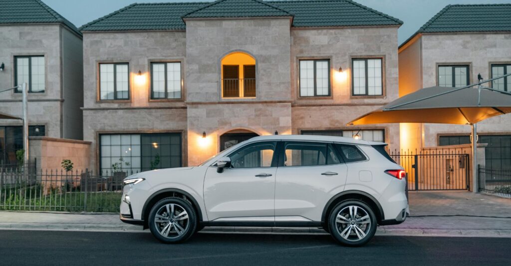 car in front of stone house